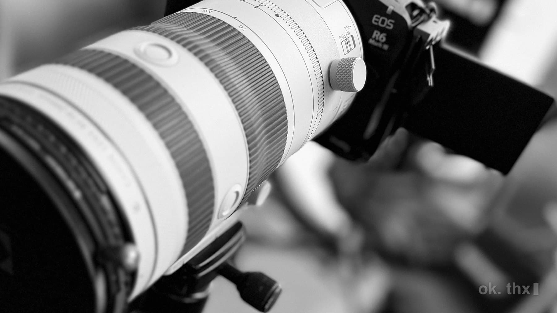 A long white telephoto lens mounted on a camera body