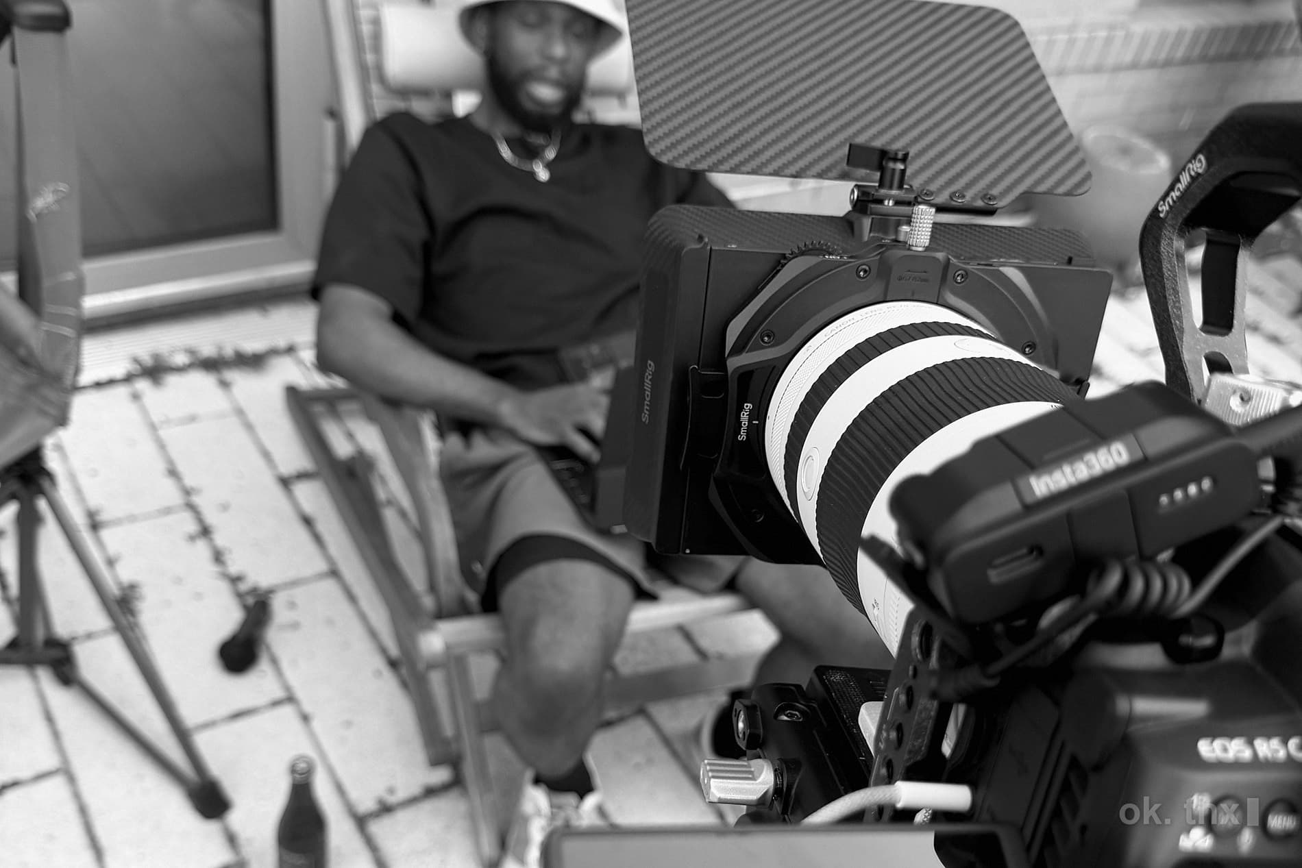 A rooftop shoot in progress: a camera on sticks, a flag, and a seat between takes