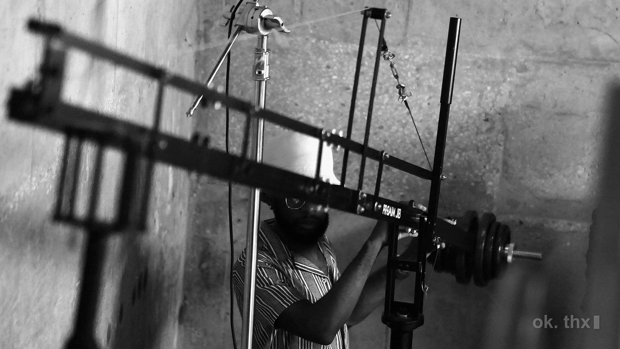 A jib arm counterweighted against a concrete wall, an operator working it from underneath