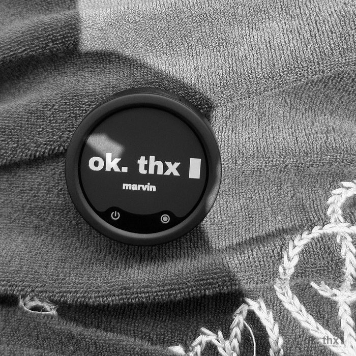 An e-ink crew badge reading ok. thx, pinned to a towelling top