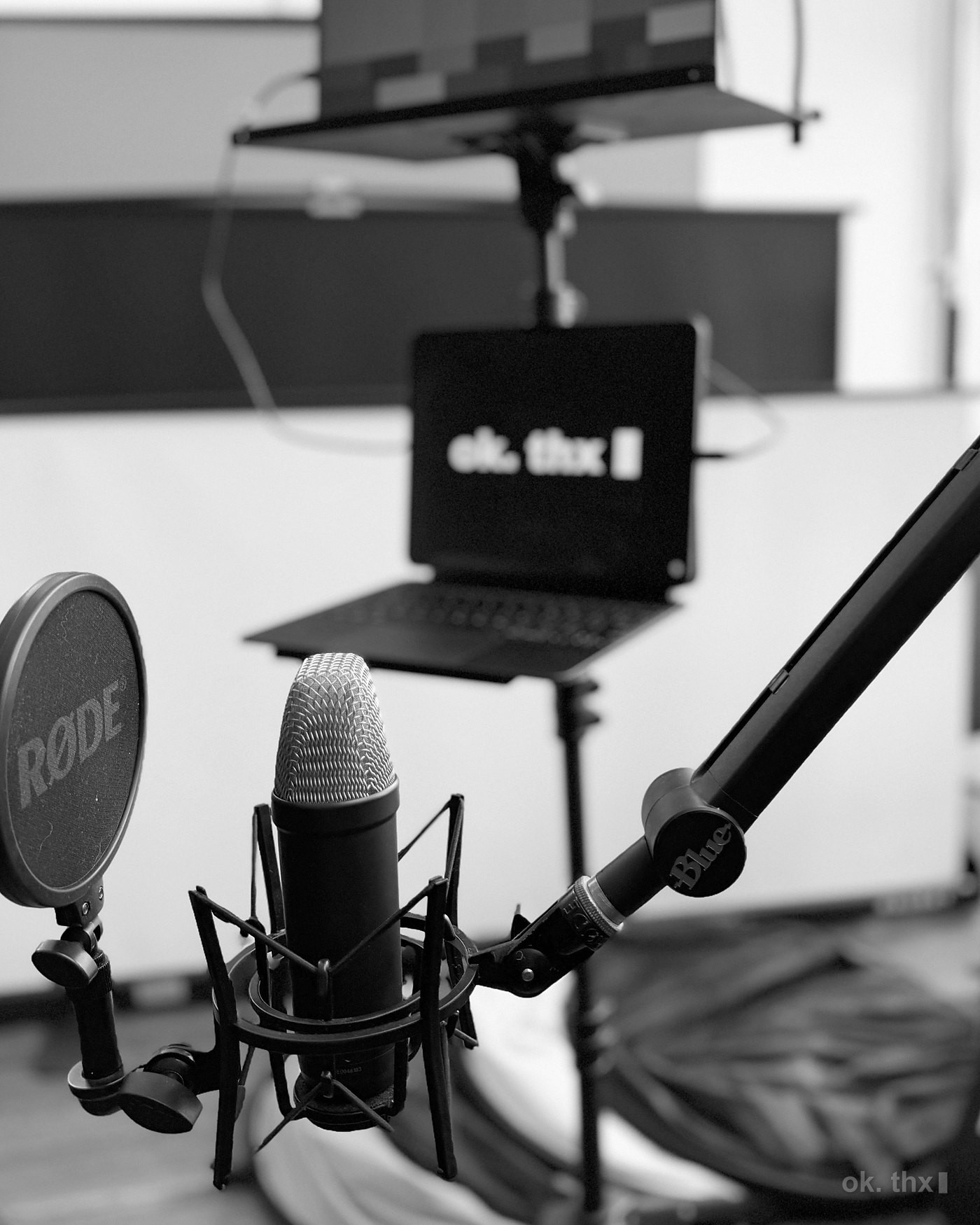 A prompter, a large-diaphragm microphone on a boom, and a laptop